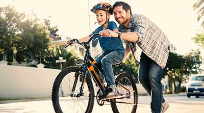Image of a man teaching a child to ride a bike