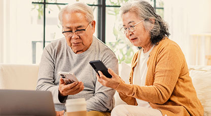 Image of two older people looking at their phones