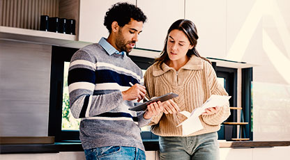 Image of a woman and man looking at a document and calculating costs together in a new house