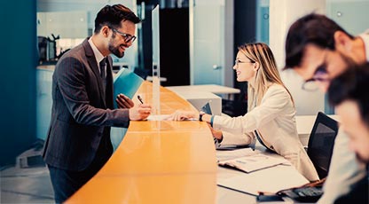 Image of a bank employee helping someone at a branch 