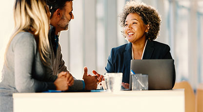 Image of two older people sitting in an office and talking