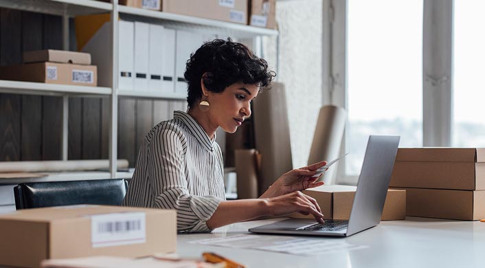 Person in front of computer typing in back office business setting