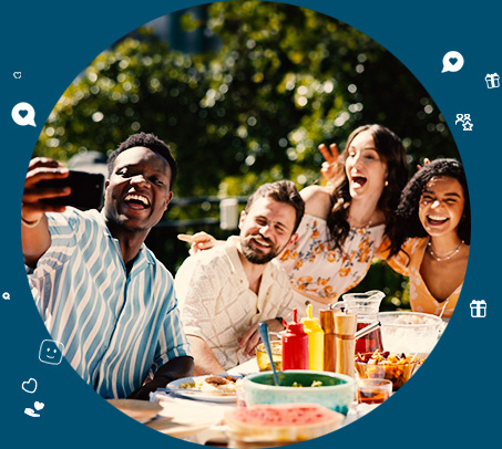 People hanging out on a picnic table taking a selfie