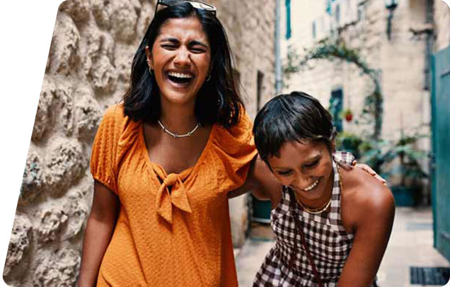 Two people laughin as they are walking through a quaint village alley