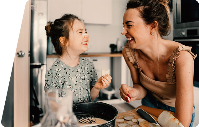 Person with a child laughing with each other with food on their noses