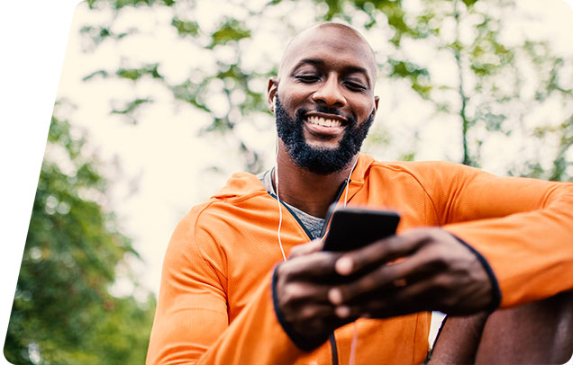 Person with headphones in looking at phone and smiling