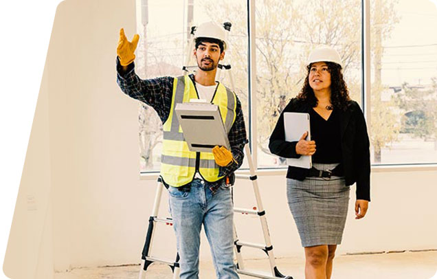 Image of two adults inspecting a construction site wearing hard hats
