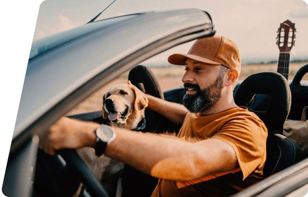A guy driving with a dog