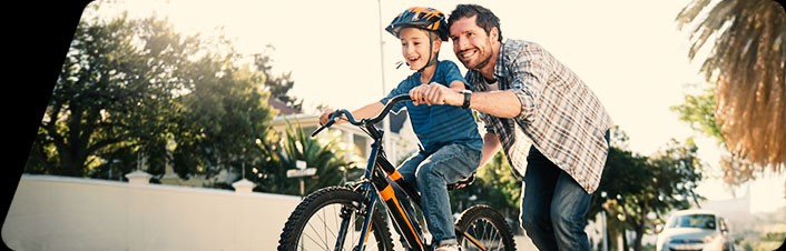Image of a man teaching a child to ride a bike