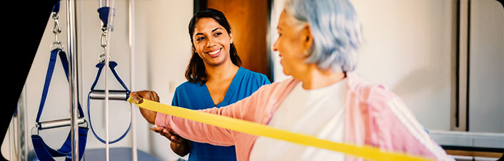 Image of a physical therapist assisting an older woman exercise