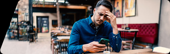 Image of a man looking at his phone while sitting in a restaurant 