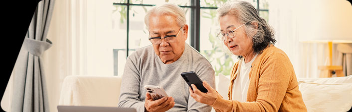 Image of two older people looking at their phones