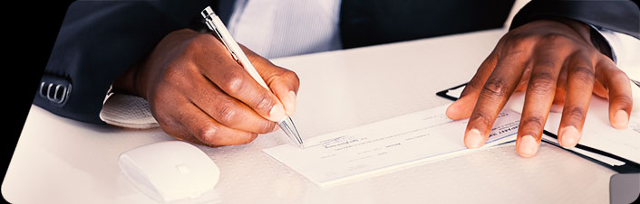Image of someone signing a check