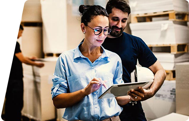 Two people looking at a tablet in a warehouse